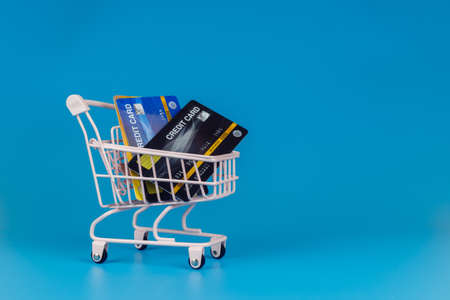 Shopping cart with credit card on blue background, business and purchase concept.の写真素材