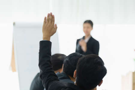 business person showing hand up for presentation in meeting room seminar training. question meeting concept.の写真素材
