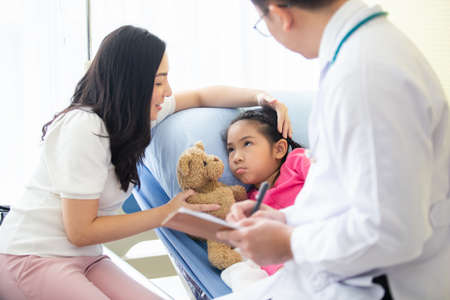 Sick child girl on bed in hospital with mother take care, Doctor doing treatment. healthy and care...