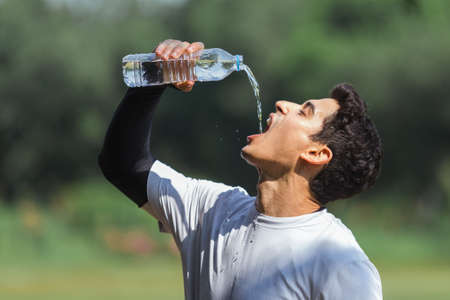 Sport man drinking water from bottle after exercise.