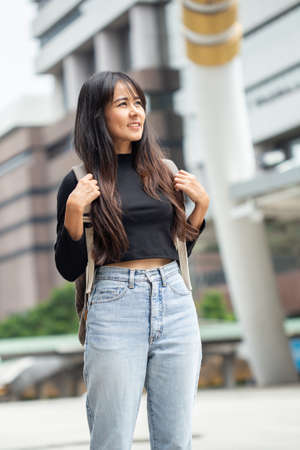 Portrait of asian young woman with backpack in the cityの写真素材