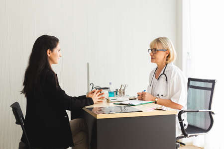 Senior female doctor and patient talking explaining medical informations and diagnosis, Treatment at hospital.の写真素材