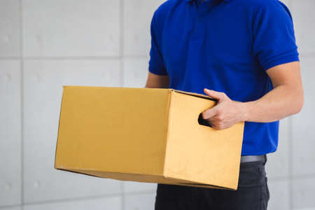 Man blue shirt holding box delivery service.の写真素材