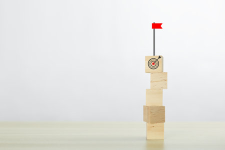 Stack wooden block cube with goal and flag icon, successful growing business concept.の写真素材