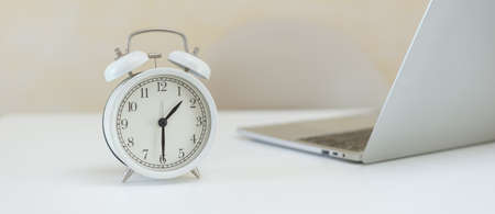 Analog white retro alarm clock on office table. working time concept.の写真素材