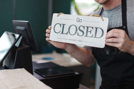men barista holding sign wooden text open, welcome entrance shop.の写真素材