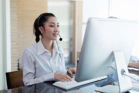 asian beautiful woman wearing headsets worker call center. working customer support service operator. communication in corporate, Business advisor concept.の写真素材