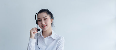 Asian woman business operator with microphone at work, Call center, support telemarketing at white background. crop image banner.の写真素材