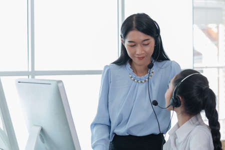 Woman operators team with microphone and computer at work, Call center, support telemarketing. communication receptionist.の写真素材