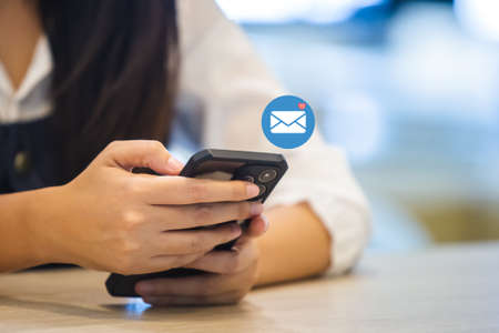 woman using smartphone with notification email icon, message media network digital online information.の写真素材