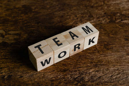 Wooden block cube with alphabet text "TEAMWORK" on wood table. Working together in organization for sustainable success. teamwork and partnership concept.の写真素材