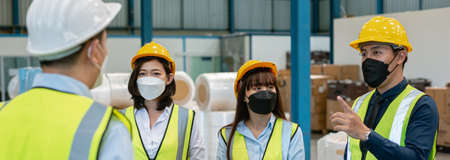 Teamwork engineer in uniform wear protection mask brainstorming workshop industrial factory building. meeting worker team.の写真素材