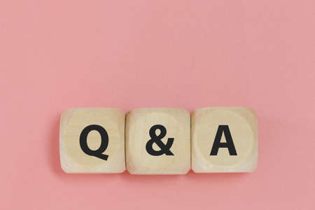 Q and A text on wooden cube block pink background. word question answer symbol. Question Ask...