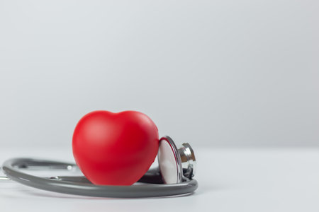 Diagnosis cardiologist concept. Red heart with stethoscope on white background. Equipment check heartbeat and pulse of patient.の写真素材