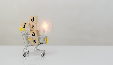 Alphabet text word IDEAS on wooden block cube and light bulb in shopping cart. symbol of creativity, Ideas, and creative concepts.の写真素材
