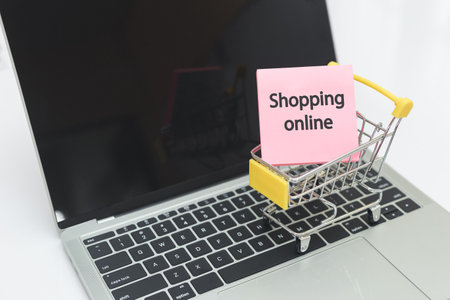 Sticky post notepaper with text Shopping online in shopping cart on laptop. Shopping online concept.の写真素材