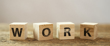 Wooden block cube with alphabet text "WORK" on wood table. education working information. business job concept.の写真素材