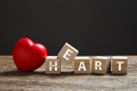 Red heart, wooden block cube with alphabet text HEART on wood table. â€‹love and health...