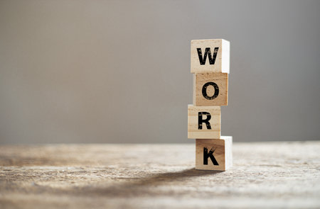 Wooden block cube with alphabet text "WORK" on wood table. education working information. business job concept.の写真素材