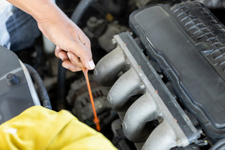 Repairman auto mechanic check engine oil condition. man worker service engine mechanic garage. Transportation repair service concept.の写真素材
