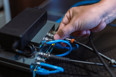 Male hand working, connecting cable SDI and HDMI to Wireless Video Transmitter and receiver system. Television studio live broadcast. media set production.の写真素材