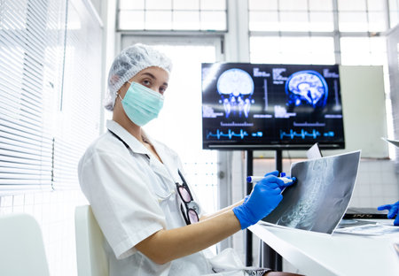 young female medical were mask and blue glove Take pen and point it at the x-ray film. Learn about...