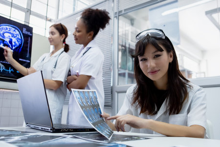Female medical student study in class room. medical students studying human brain disease diagnosis through learning from X-ray film. Learn about brain surgery for diagnosis.の写真素材