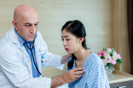 Doctor using stethoscope check up heart rate woman patient. exam diagnosis heartbeat check-up in hospital.の写真素材