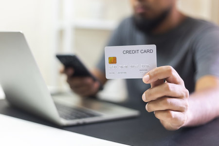 Close up credit card. Man holding credit card using laptop at office table. Online shopping and payment. Electronic money transfer. Transaction exchange technology of banking.の写真素材