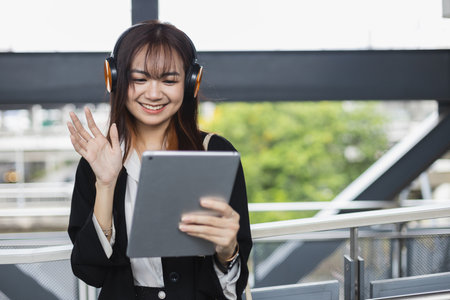 Asian beautiful female video conference calling on digital tablet wear headphones online app....