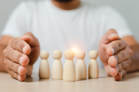 Man hands are encircle group of wooden puppet with leadership corporate of teamwork. Business team...
