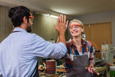 Carpenter man and woman touching hand successful. working wood design at workplace. factory industry woodwork. wooden small business factory.の写真素材