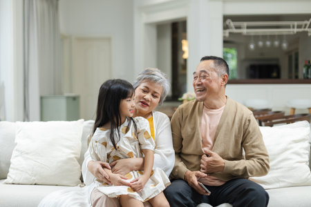 Happy Family Grandfather Grandmother and Granddaughter having fun living room at home. connects...