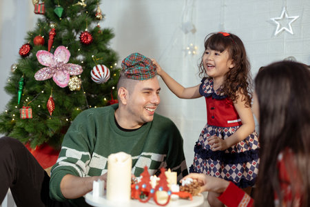 Happy family christmas day. Parents and daughter celebrate Christmas happily in their own home. enjoying holiday merry festive activities.の写真素材
