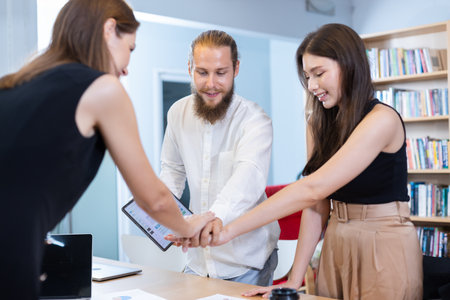 Group of business people brainstorming joining hand success report analyze work goal graph at table...