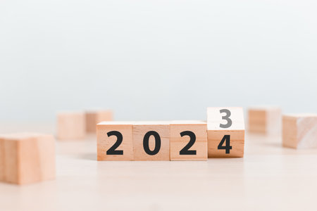 woodblocks cubes with a number 2023 change to 2024 on wood table. new year 2023- 2024 concept.