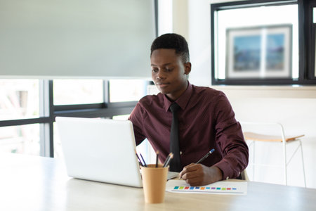 Young businessman handsome African American black skin working on laptop at office. businessperson...