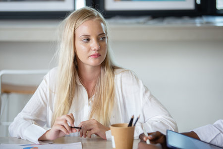 Female blonde hair employee sitting attentively listening to meetings in company.Business people meeting share ideas meeting at office. brainstorming discussion conference.の写真素材