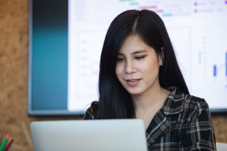 Asian businesswoman using laptop computer, working at office. Female office worker relax time. freelance professional success work.の写真素材