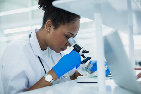 Science department students are working looking through microscope research in medical science. Analyze medical data advanced learning scientific chemistry biology. women scientist in laboratory.の写真素材
