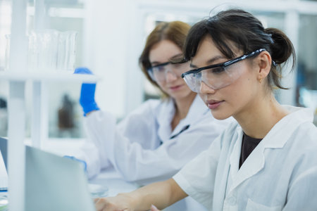 Science department students are working looking through microscope research in medical science. Analyze medical data advanced learning scientific chemistry biology. women scientist in laboratory.の写真素材