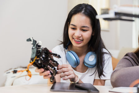 Happy two girl teen smile with braces students education stem hand robot model study in classroom....