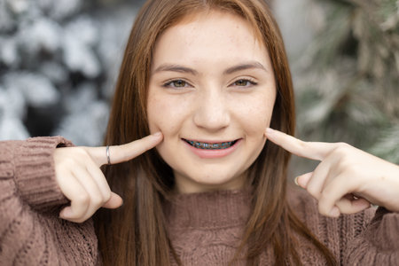 Close up portrait of face young caucasian beautiful woman blond hair smiling with braces. Happy girl...