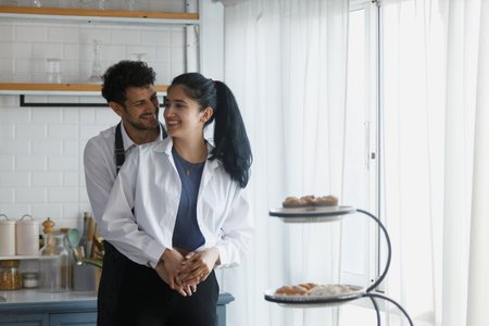 man and woman in kitchen, Couple chef cooking in kitchen at home. Male and female Hug in a sweet...