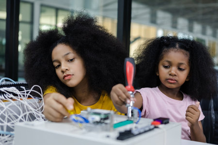 children girl with afro hairstyle education electronic on table at class room.  learning innovation electronic for future AI. electric system skill training. STEM education concept.の写真素材