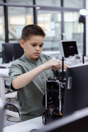 Boy in electronic class room. Kid boy education electronic AI class and touching screen STEAM digital. learning innovation electronic for future AI. electric system skill training. STEM education concept.の写真素材