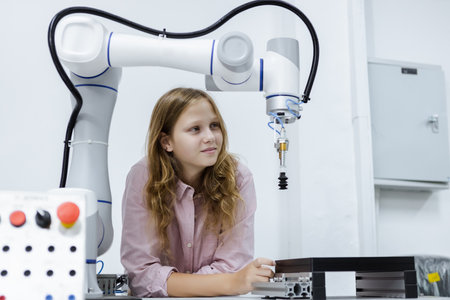 Girl caucasoid education electronic robotic arm on table at class room. learning innovation robot...