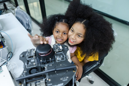 children girl with afro hairstyle education electronic on table at class room. learning innovation electronic for future AI. electric system skill training. STEM education concept.の写真素材