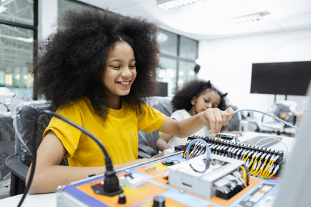 children girl with afro hairstyle education electronic on table at class room.  learning innovation electronic for future AI. electric system skill training. STEM education concept.の写真素材