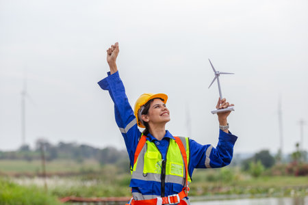 Female engineer holding wind turbine simulator. Technology protects the environment and reduces...